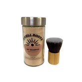 A Swell Roots Dry Shampoo jar filled with all-natural powder sits beside a bamboo-handled, soft-bristled makeup brush, both displayed on a white background.
